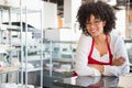 Smiling waitress with glasses leaning on counter