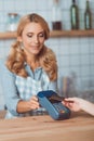 smiling waitress holding cardkey reader while customer paying