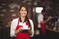 Smiling waitress holding a cup of coffee Royalty Free Stock Photo