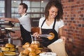 Smiling waitress putting bread roll in paper bag Royalty Free Stock Photo