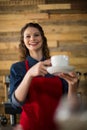 Smiling waitress serving cup of coffee at counter Royalty Free Stock Photo