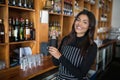 Smiling waitress shaking cocktail at bar counter in bar Royalty Free Stock Photo