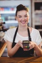 Smiling waitress showing credit card machine Royalty Free Stock Photo