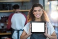 Smiling waitress showing digital tablet at counter in cafÃÂ© Royalty Free Stock Photo