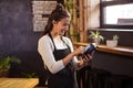 Smiling waitress using a bank card reader Royalty Free Stock Photo