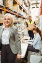 Smiling warehouse manager leaning on desk