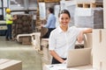 Smiling warehouse manager using laptop