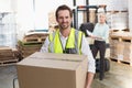 Smiling warehouse worker carrying box Royalty Free Stock Photo