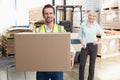 Smiling warehouse worker carrying box Royalty Free Stock Photo