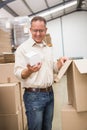 Smiling warehouse worker holding small box Royalty Free Stock Photo