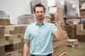 Smiling warehouse worker showing a small box Royalty Free Stock Photo