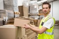 Smiling warehouse worker taking a box Royalty Free Stock Photo