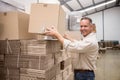 Smiling warehouse worker taking a box Royalty Free Stock Photo