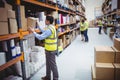 Smiling warehouse worker taking package in the shelf Royalty Free Stock Photo