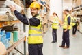 Smiling warehouse worker taking package in the shelf Royalty Free Stock Photo