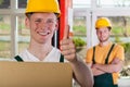 Smiling warehouseman showing thumbs up sign