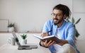 Smiling Western Freelancer Guy Taking Notes At Workplace In Home Office Royalty Free Stock Photo