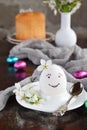 Smiling white egg and flowers on clay plate. Happy Easter card. Holidays breakfast concept. Festive table place setting decoration Royalty Free Stock Photo