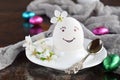 Smiling white egg and flowers on clay plate. Happy Easter card. Holidays breakfast concept. Festive table place setting decoration Royalty Free Stock Photo