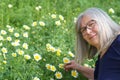 mature woman picking daisies in the field Royalty Free Stock Photo