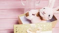 Smiling white plush bunny in a box on a pink wooden table background. Pastel color. Empty space for text. Close-up. Toy banner Royalty Free Stock Photo