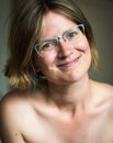 Smiling white thrity year old woman with bare shoulders and glasses Royalty Free Stock Photo