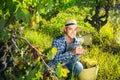 Smiling winemaker offering wine for testing in vineyard