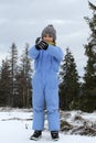 Smiling winter child with ski outfit playing with cold snow