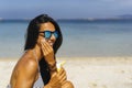 Smiling woman applying sun protection cream on her face in the beach Royalty Free Stock Photo