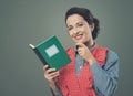 Smiling woman in apron with cookbook