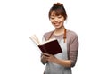 smiling woman in apron reading cook book Royalty Free Stock Photo