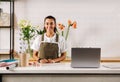 Smiling woman in apron standing at counter