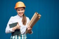 Smiling woman architect holding book and paper plan Royalty Free Stock Photo