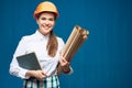 Smiling woman architect holding book and paper plan Royalty Free Stock Photo