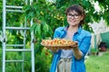 Smiling woman with basket of fresh yellow cherries near cherry tree in summer garden Royalty Free Stock Photo