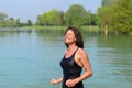 Smiling woman in bathing suit wading in lake