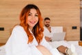 Smiling woman in a bathrobe sitting on bed Royalty Free Stock Photo