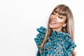 Smiling woman with beautiful teeth. Fashion photo of a happy young woman in a pretty dress with flowers posing over white Royalty Free Stock Photo