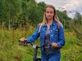 Woman with bicycle walking on rural road Royalty Free Stock Photo