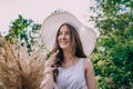 Smiling woman in a big white hat with a bouquet on a sunny day. Royalty Free Stock Photo
