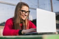 woman with black glasses working on laptop at outdoor coffee shop table Royalty Free Stock Photo