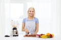 Smiling woman with blender preparing shake at home Royalty Free Stock Photo