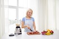 Smiling woman with blender preparing shake at home Royalty Free Stock Photo