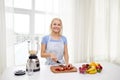 Smiling woman with blender preparing shake at home Royalty Free Stock Photo