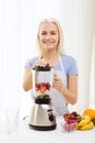 Smiling woman with blender preparing shake at home Royalty Free Stock Photo