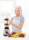 Smiling woman with blender preparing shake at home Royalty Free Stock Photo