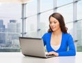 Smiling woman in blue clothes with laptop computer Royalty Free Stock Photo