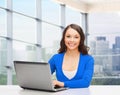 Smiling woman in blue clothes with laptop computer Royalty Free Stock Photo