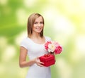 Smiling woman with bouquet of flowers and gift box