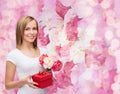 Smiling woman with bouquet of flowers and gift box